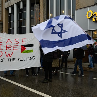 Protestors face off with pro-Palestine signs and an Israel flag.