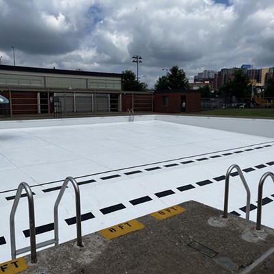 A large, empty swimming pool with fresh white paint and black lane markers