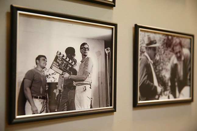 Two framed, black and white photos of Night of the Living Dead hang on a wall.