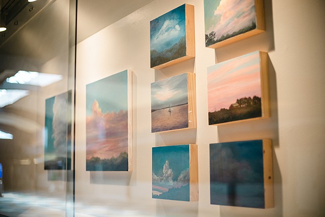 Paintings on a wall showing landscapes