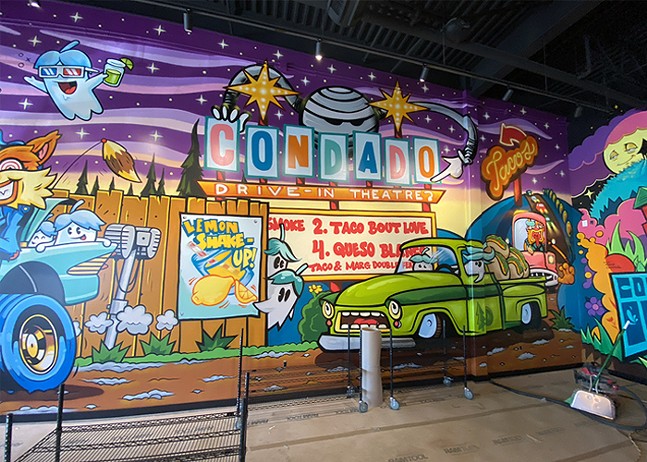 A fun, colorful mural at a Condado Tacos depicts creatures going to a drive-in movie theater.