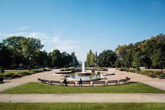 A large, in-ground fountain sits at the entrance of Highland Park on a sunny day in Pittsburgh