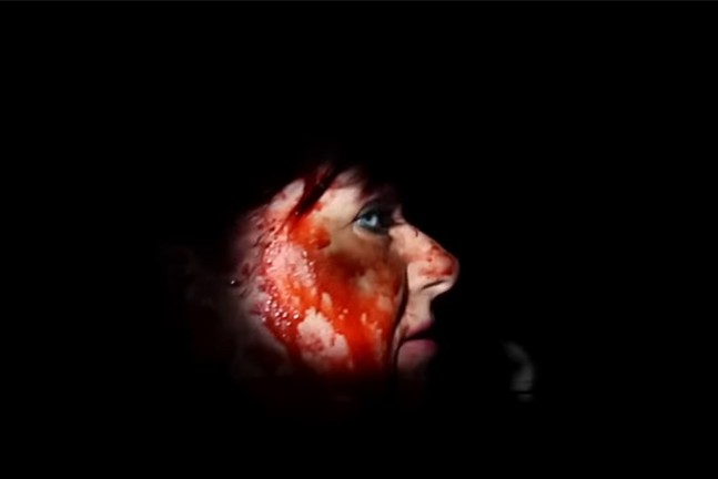 Close up on a white woman's face covered in blood.