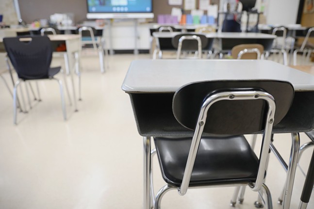 Desks are shown in a classroom.