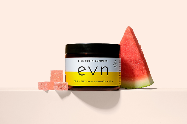 Image of a jar of evn Live Rosin Gummies on a pale pink background, with three loose gummies and a slice of watermelon next to it