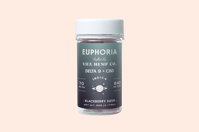 Pale pink background, jar of gummies with white lid and grey label that reads "euphoria crafted by VIIA hemp co. delta 9 + cbd indica blackberry kush"