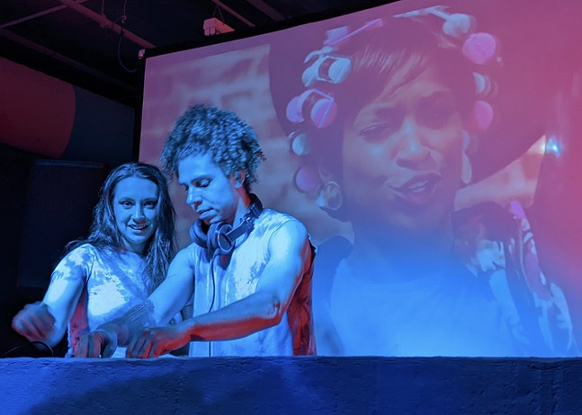 A female DJ looks straight at the camera as her male partner works the turntables at Belvederes Ultra-Dive