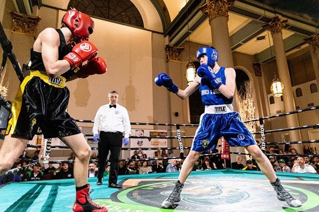 Two boxers square off in a ring inside an ornate Romanesque church