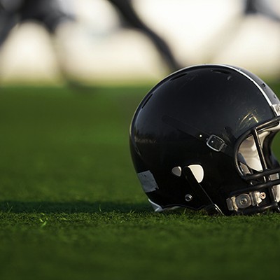 A football helmet sitting on green turf