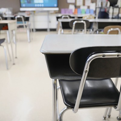Desks are shown in a classroom.